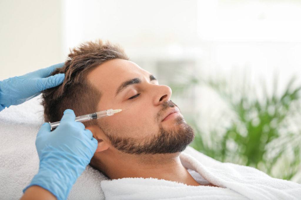 Handsome Man Receiving Filler Injection In Beauty Salon